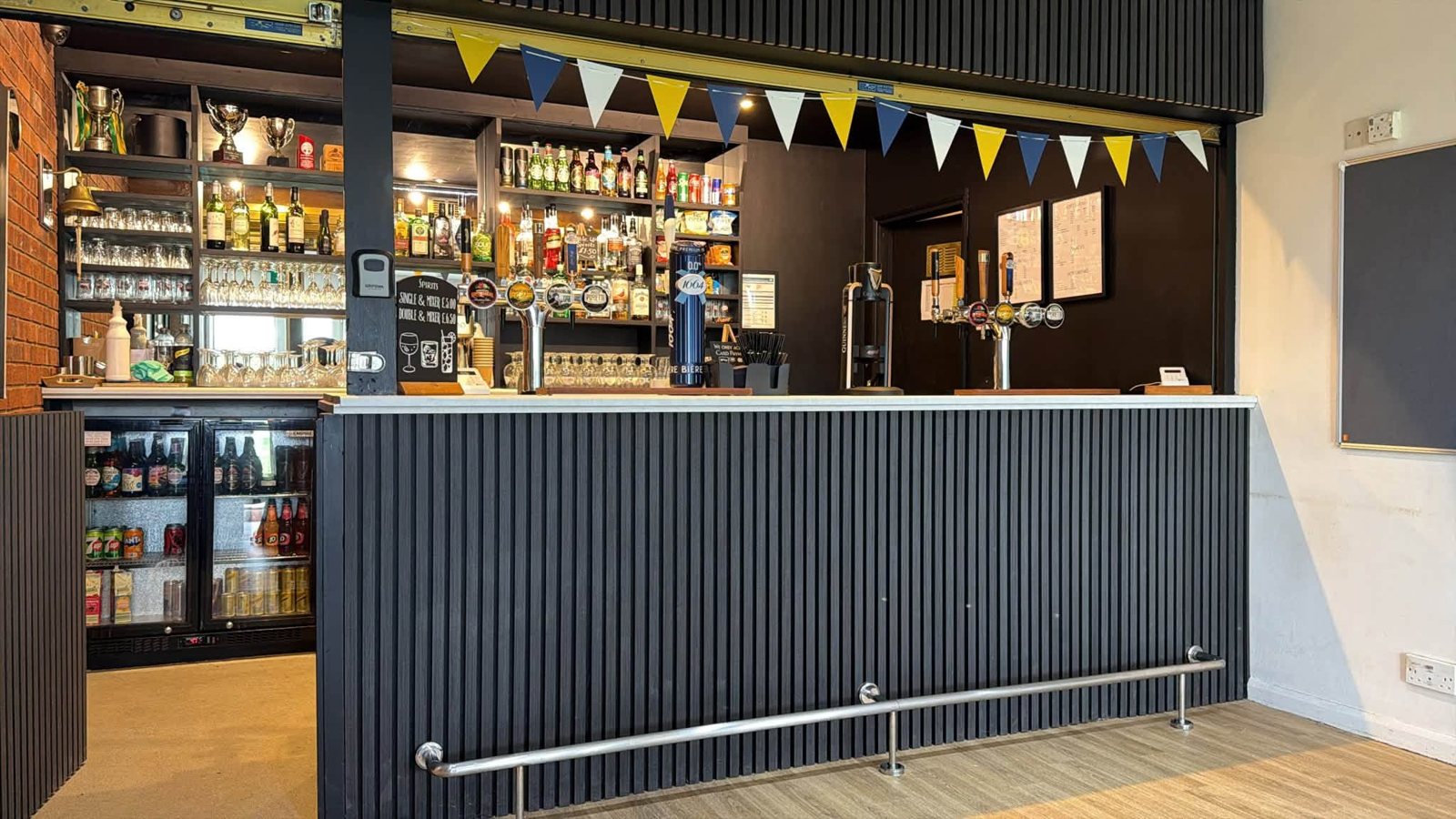 The refurbished clubhouse bar, with bunting, trophies and a full range of drinks