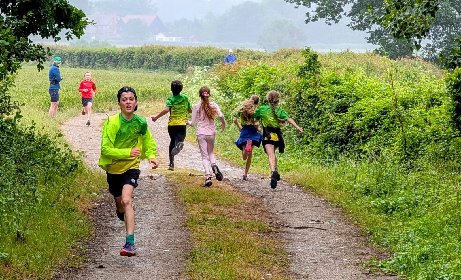 Junior members running along a farm track on a wet Saturday training session